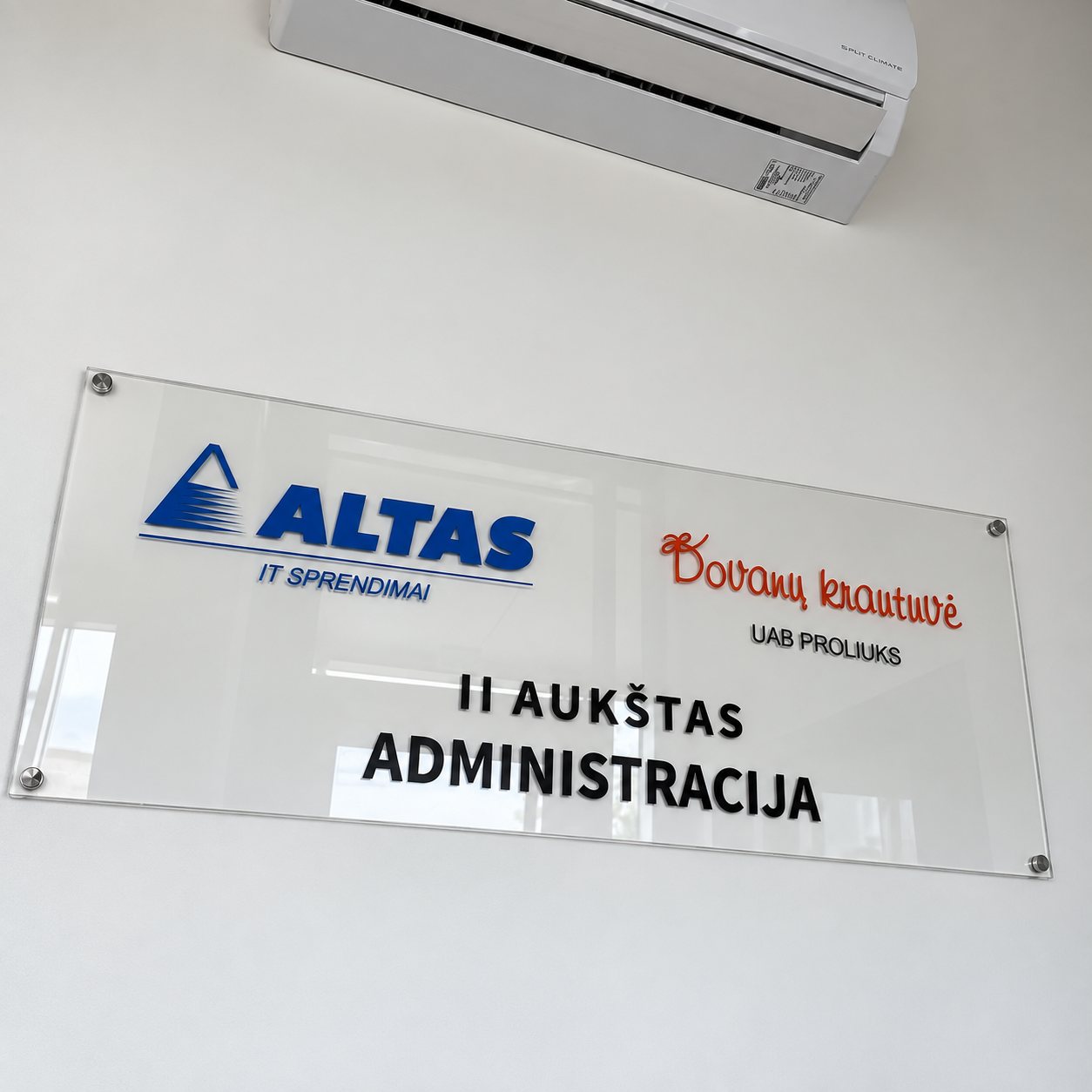 Informacinė lentelė su įmonių logotipais ant sienos