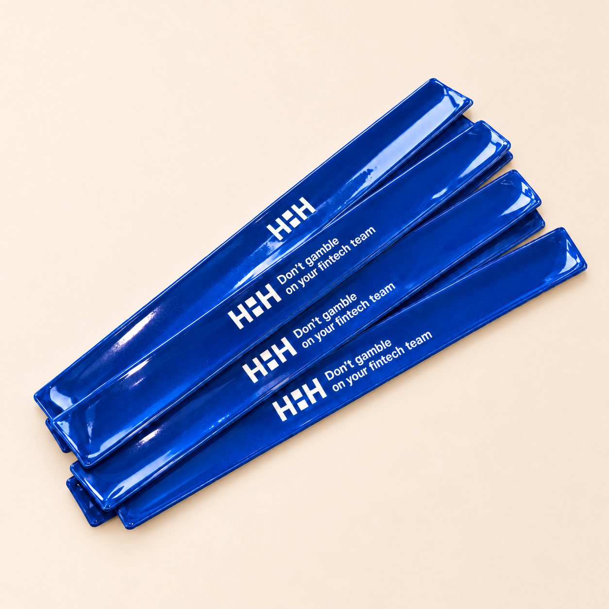 Mėlyni atšvaitai su „HHHub“ logotipu ir baltu užrašu neutraliame kreminiame fone
